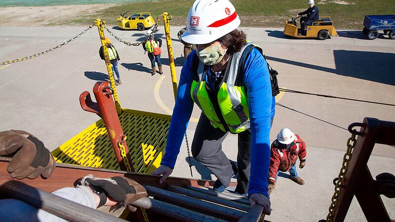 A CCHD employee named Jill climbs aboard a vessel for the "Shots on Ships" program.