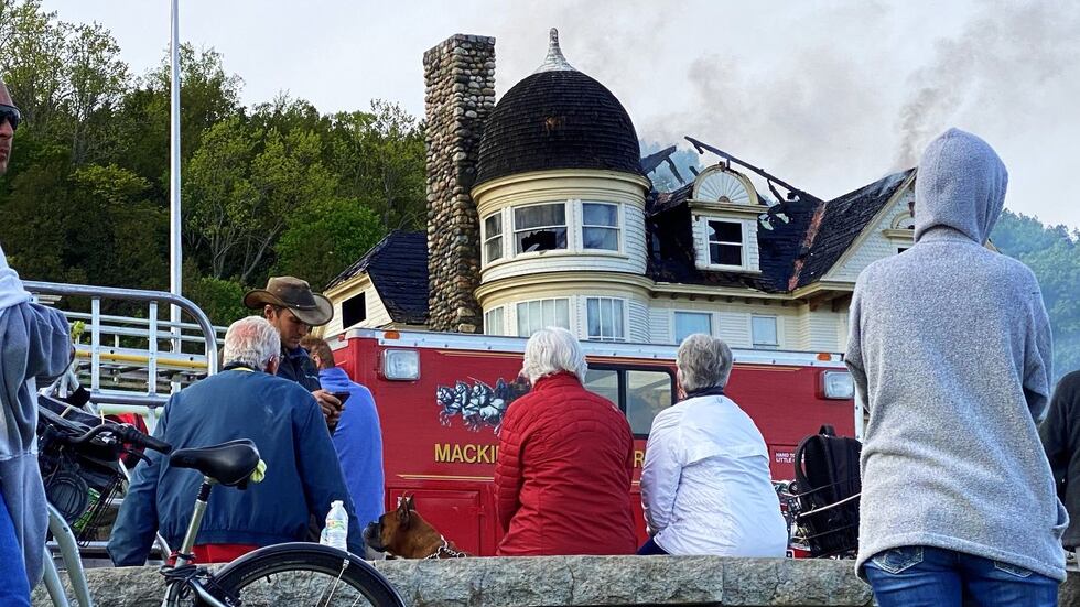 The Stingel family looks on as firefighting crews put out the fire at the Brigadoon Cottage on...
