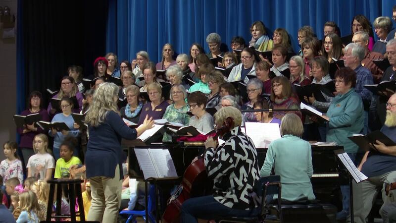 Crystal Hogan (standing next to piano) directs the chorus